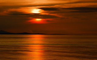 Sunset water boat mountain red - a sunset over a body of water free wallpaper