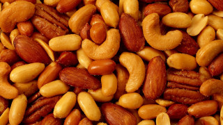 Nuts pile with orange pancake - product photo free wallpaper