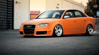 Orange car parking lot building - an orange car free wallpaper