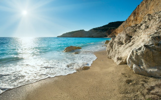 Sandy beach rock cliff blue 2 - blue water free wallpaper