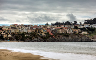 Beach houses hill water boat - a body of water below free wallpaper