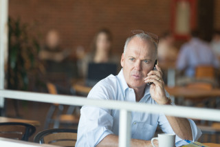Man sitting table talking cellphone - institutional free wallpaper