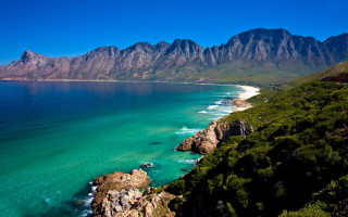 Beach mountains water sand sky - a view of a beach free wallpaper