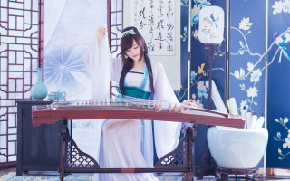 Woman green dress playing instrument - a blue wall free wallpaper