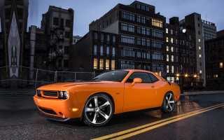 Bright orange sports car night 4 - a city street in the background free wallpaper