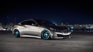 Silver car blue wheels night - a city skyline in the background free wallpaper