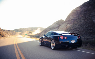 Black sports car mountain road 6 - a sky background and a mountain range in the distance free wallpaper