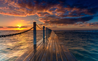 Sunset dock water clouds cityscape - a wooden dock free wallpaper