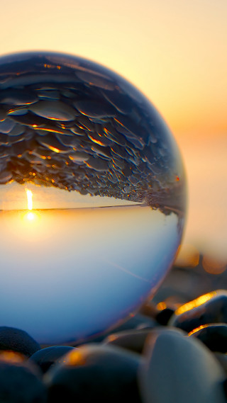 Glass ball sunset background rocks - a sunset in the background free wallpaper