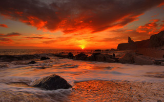 Sunset ocean waves rocks lighthouse - a lighthouse in the distance free wallpaper