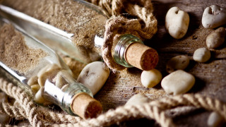 Bottles sand rocks rope stilllife - a table top free wallpaper