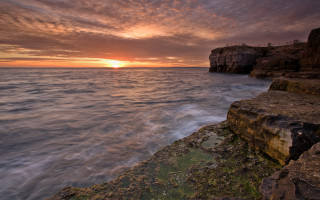 Sunset ocean rocky cliff bridge - a sunset over the ocean free wallpaper