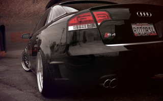 Black car brick building tail - a black car free wallpaper