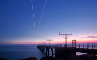 Pier plane sunset contrails water 4 - a body of water below free wallpaper