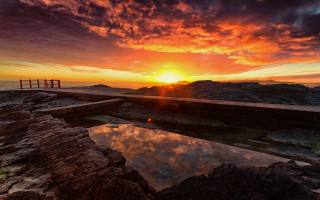 Rocky beach sunset ocean lighthouse - a bench free wallpaper