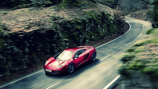 Red sports car winding forest - road free wallpaper