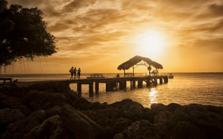Pier thatched roof sunset people - sunset time free wallpaper