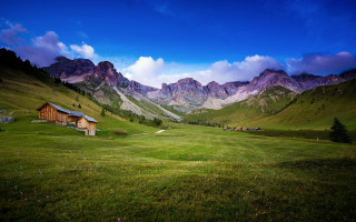 Green field house mountains clouds 3 - a house in the middle of it free wallpaper