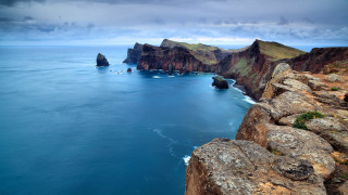 Rocky cliffs ocean cloudy sky - a large body of water free wallpaper