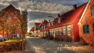 Cobblestone street redbrick buildings bluecar - a blue car free wallpaper