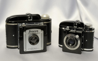 Two old fashioned cameras black - a white cloth free wallpaper