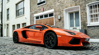 Bright orange sports car cobblestone 2 - a cobblestone street in front free wallpaper
