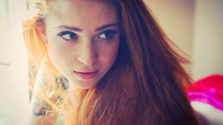 Woman red hair serious look - her face and shoulder free wallpaper