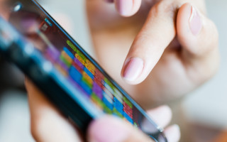 Woman holding cellphone blurry background - her finger free wallpaper