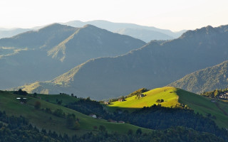 Green hillside houses mountains lake - a few house free wallpaper