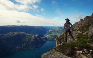 Cliff lake mountains backpack man - a backpack free wallpaper