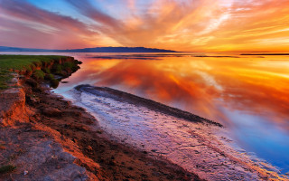 Sunset water clouds shore grass 2 - a small patch of grass free wallpaper