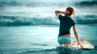 Woman blue shirt shorts surfboard - flowing hair free wallpaper