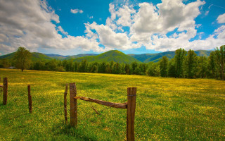 Fence mountains clouds green field - a green field free wallpaper