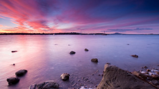 Sunset ocean rocks distant island - rich moody colour free wallpaper