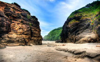 Rocky beach mountains people sky - a few person free wallpaper