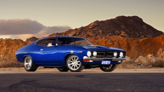 Blue muscle car mountain sunset - a cloudy sky in the background free wallpaper