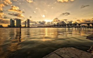 Sunset water bridge cityscape clouds - a sunset over a body of water free wallpaper
