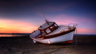 Boat beach sunset water sky - a sky background and a body of water free wallpaper