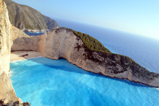Large rock formation water cliff - a blue ocean free wallpaper