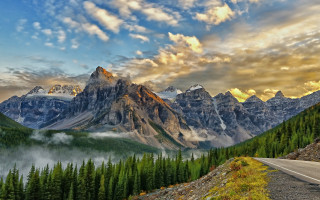 Mountain road forest sunset sky - a scenic view of a mountain range free wallpaper