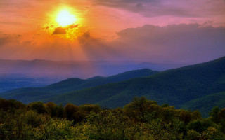 Sunset mountain range crepuscular rays - a sunset over a mountain range free wallpaper