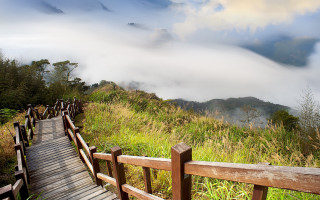 Wooden walkway lush green hillside - a wooden fence free wallpaper