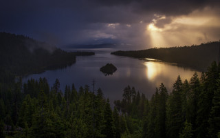 Lake trees sunbeams cloudy sky - a small island in the middle free wallpaper