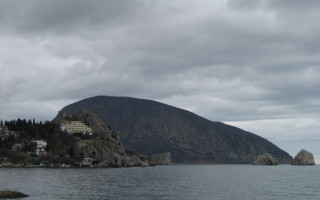 Mountain village ocean cloudy sky - a body of water below free wallpaper
