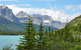 Mountain lake trees snowy horizon - the foreground and a mountain range in the background free wallpaper