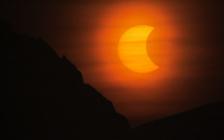 Bright sun over mountains night - a dark sky free wallpaper