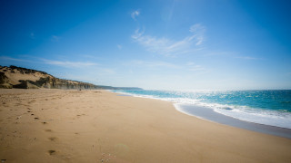 Sandy beach footprints blue sky - a sandy beach free wallpaper