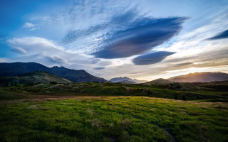 Grassy field mountains sunset clouds - a grassy field free wallpaper