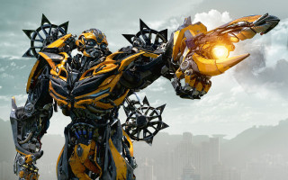 Yellow black robot gun city - his hand and a city in the background free wallpaper