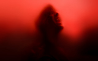 Blurry person red background silhouette - a red wall behind them free wallpaper